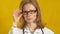 Young woman doctor. Yellow background. The concept of medicine.