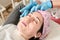 Young woman does professional facial massage in the beauty salon