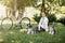 Young woman with dogs and bicycle having picnic in the park