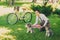 Young woman with dogs and bicycle having picnic in the park