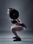 Young woman doing barbell squats