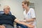 Young woman doing blood test for senior man with diabetes