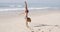 Young Woman Doing Cartwheel On Beach