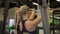 Young woman doing exercise in machine in modern gym.