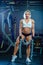 Young woman doing exercises with heavy chain in gym. Classic bodybuilding. Muscular blonde fitness woman doing