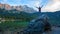 Young woman doing gymnastics on a big rock at eibsee lake shore. evening scenery bavarian mountains