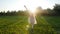 Young woman doing a handstand at sunset meadow outdoors