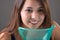 Young woman doing inhalation with a medical vaporizer nebulizer machine on grey background