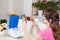 Young woman doing inhalation with a nebulizer at home. dials the doctor`s number for a consultation