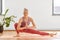 Young woman doing low side lunge at yoga studio