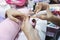 Young woman doing manicure at beauty salon fingernails care nail paint pink color
