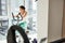 Young woman doing morning cardio workout exercising on stationary bike