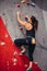 Young woman doing professional bouldering in climbing gym indoors