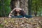 young woman doing revolved seated angle yoga pose outdoors