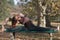 young woman doing revolved seated angle yoga pose in the park