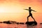 Young Woman doing the Warrior Yoga Position in Front of the Ocean