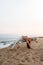 Young woman doing yoga at the beach. Female practices the wild thing yoga pose at sunset. Copy space. Vertical image.