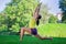 Young woman doing yoga exercises in park - crescent moon pose