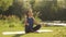 Young woman doing yoga exercises in summer city park. Health lifestyle concept. Portrait of peaceful female meditating in the morn
