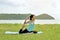 Young woman is doing yoga near the sea