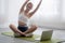 Young woman doing yoga with sitting and stretch muscles hands on mat at home.