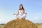 Young woman doing yoga on a straw bale