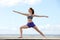 Young woman doing yoga stretch at the beach