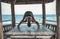 Young woman doing yoga in the wooden gazebo at the beach