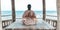 Young woman doing yoga in the wooden gazebo at the beach