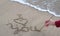 A young woman draws I love you on the sand