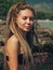 Young woman with dreadlocks sitting on the rocks