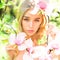Young woman on dreamy face. Tender blonde teen near magnolia flowers. Young woman enjoy flowers in garden. Spring bloom