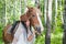 Young woman in the dress of fiancee next to a horse