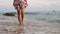Young woman in dress walking on beach