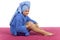 Young woman dressed blue bathrobe rubbing cream into her leg