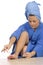 Young woman dressed blue bathrobe and towel painting nails