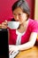 Young woman drinking cappuccino using her laptop