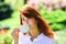 Young woman drinking coffe in spring pakr. Beautiful woman holding a coffee cup in her hand.