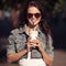 Young woman drinking coffee from paper cup on a city street