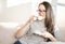 Young woman drinking coffee on sofa at home