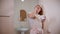 A young woman drinking coffee standing in the bathroom doorway at the morning