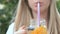 Young woman drinking fresh lemonade with fruits