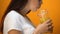 Young woman drinking orange juice and smiling, healthy diet beverages, vitamins