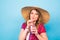 Young woman drinking tasty smoothie on blue background and copy space, vintage outfit, studio lifestyle portrait