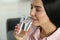 Young woman drinking water indoors, closeup. Refreshing drink