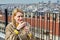 Young woman drinks hot tea on roof of hotel overlooking cityscape of Istanbul in Turkey.