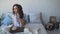 Young woman drinks morning coffee and pies breakfast in the bedroom.