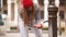 A young woman drinks water from a street fountain - filling her hands with water