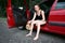 Young woman driver resting in a red car, take off their shoes, happy travel concept, women`s high heel shoes are yellow