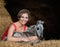 Young woman with dun foal lying on hay. American Miniature Horse